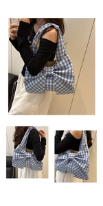 Close-up of blue gingham tote bag featuring a large decorative bow and fabric texture