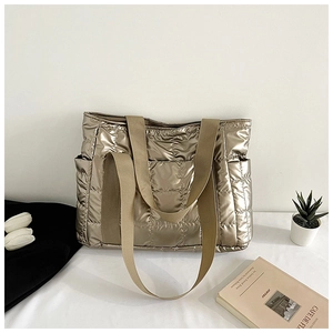 Makroaufnahme der champagnergoldenen gesteppten Tragetasche mit Metallic-Finish