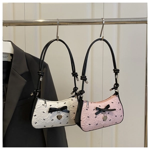Close-up of seersucker texture with black bow patterns and heart charms on bags