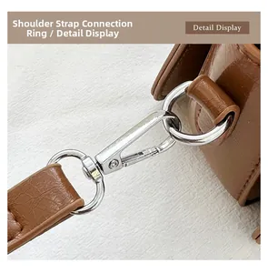 Detail of silver lobster clasp and D-ring on vintage brown leather crossbody bag