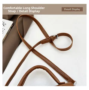 Close-up of adjustable brown leather shoulder strap with silver buckle and neat stitching