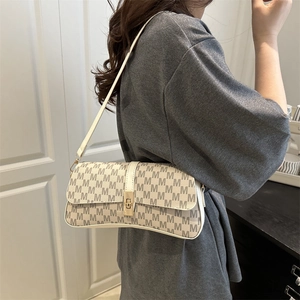 Sac bandoulière chic pour femme avec motif monogramme et fermoir doré sur modèle