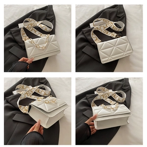 Detail view of white quilted crossbody bag with gold chain and patterned wide strap