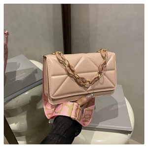 Detailed view of pink quilted handbag with thick resin chain and floral canvas strap