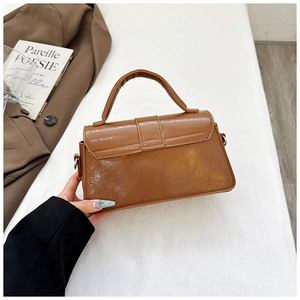 Detail of vintage brown square bag with wrinkled texture and rounded top handle