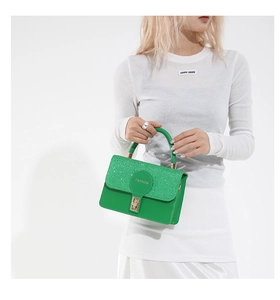 Dettaglio di borsa a mano verde con paillettes e incisione Fashion su pelle circolare
