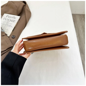 Detail view of brown leather bag bottom showing premium stitching and smooth texture