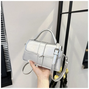 Detail of silver metallic textured crossbody bag with stylish crinkle finish and handle