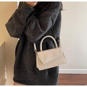 Chic cream crossbody bag shown on a shoulder with knit sweater for daily fashion