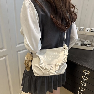 Cream faux leather crossbody bag with ruffled edges and brown plush bear charm