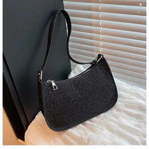 Detail of black glitter crescent underarm bag with shimmering texture and silver zipper