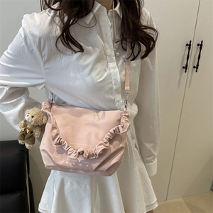 Pink pleated crossbody bag with heart graphic and a cute brown bear plush pendant