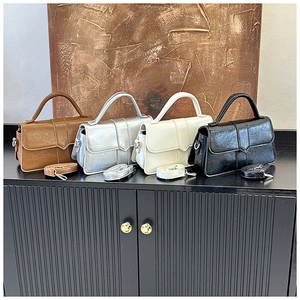 Detailed view of four retro leather crossbody bags in brown, silver, white, and black