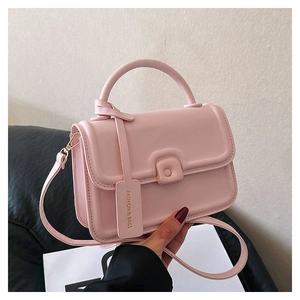 Detailed view of a pink matte PU leather crossbody bag with top handle and square flap buckle
