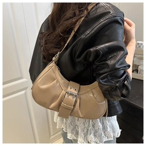 Detailed view of khaki pleated crescent bag featuring a large silver metal buckle strap