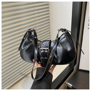 Detail of black glossy leather underarm bag featuring silver buckle and stylish pleats