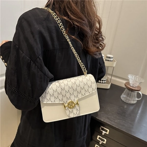 White leather crossbody bag with letter print cover and gold chain strap in life scene