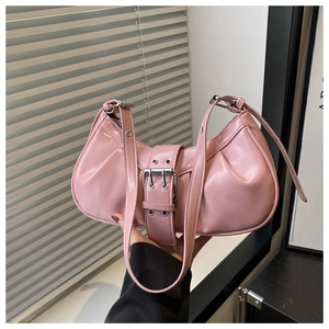 Close-up of pink glossy underarm bag featuring pleated texture and metal buckle detail