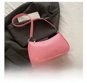 Close-up of pink shoulder bag featuring woven texture finish and metal zipper detail