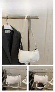 Detailed view of white woven texture underarm bag with curved design and zip closure
