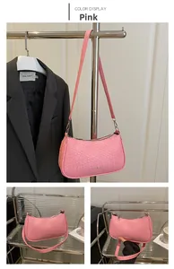 Detail of pink woven PU leather underarm bag with checkered texture and matching strap