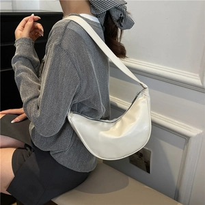 Minimalist white crescent shoulder bag in premium leather with smooth finish worn by model