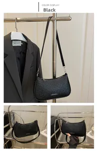 Detail of black woven crescent bag featuring adjustable shoulder strap and silver hardware