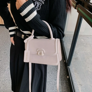 Chic cream pink crossbody bag for women with decorative knob and fashion tag hanging