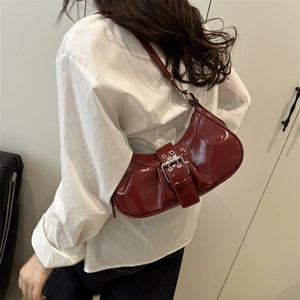 Minimalist burgundy patent leather hobo bag with pleated texture and silver buckle