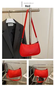 Detail of red woven texture shoulder bag featuring metallic zipper and leather strap