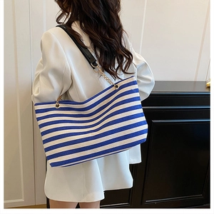 Detail of the blue and white striped tote bag with elegant chain and leather strap