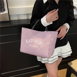 Lavender pink nylon tote bag with black and white woven handles and KATONGMU letter print