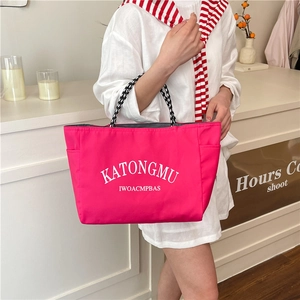 Pink canvas tote bag with check straps and white lettering for daily commuting