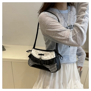 Detailed shot of lace underarm bag with bow, heart charm and monochrome patterns