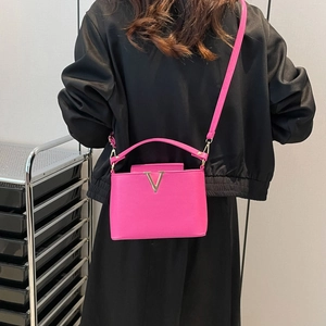 Magenta leather crossbody bag with gold V-buckle and versatile top handle strap