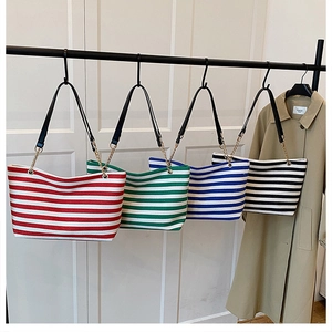 Detail view of large canvas striped tote bags with gold chains in four color options