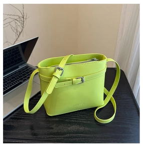 Detail of lime green bucket bag featuring premium lychee texture and silver buckle