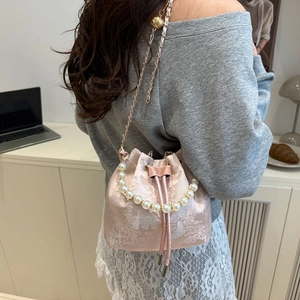 Pink silk satin bucket bag with pearl handle and floral embroidery in a classic style