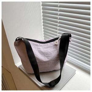 Detail of lavender nylon dumpling bag showing waterproof texture and wide strap