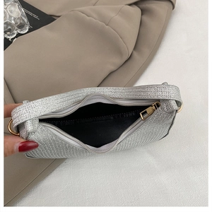 Détail d'un sac argenté scintillant avec fermeture éclair et doublure en tissu noir