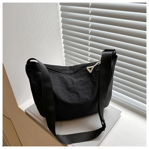 Close-up of black nylon crescent bag with textured fabric and unique triangular zipper pull