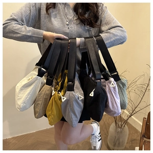Close-up of colorful nylon crossbody bags featuring unique white triangle zipper pulls