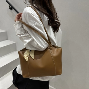 Classic brown PU leather tote bag with decorative scarf on a stylish staircase background