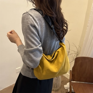 Minimalist yellow nylon crescent crossbody bag with adjustable black shoulder strap