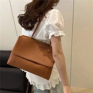 Minimalist brown leather tote bag for women shown with a stylish casual outfit