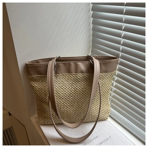 Detail of woven straw tote bag with faux leather straps under natural sunlight