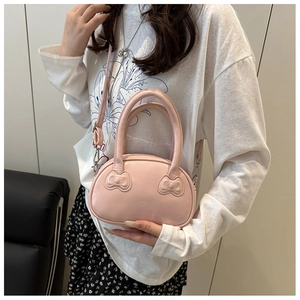 Detail of pink mini bowling bag featuring 3D bow relief accents and silver hardware