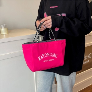 Hot pink nylon tote bag with white lettering and black and white woven rope handles