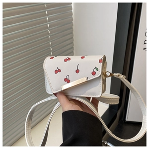 Détail du mini sac bandoulière blanc avec imprimé cerises et boucle en métal doré