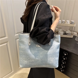 Light blue glitter tote bag with silver shoulder straps and fashion logo metal plate